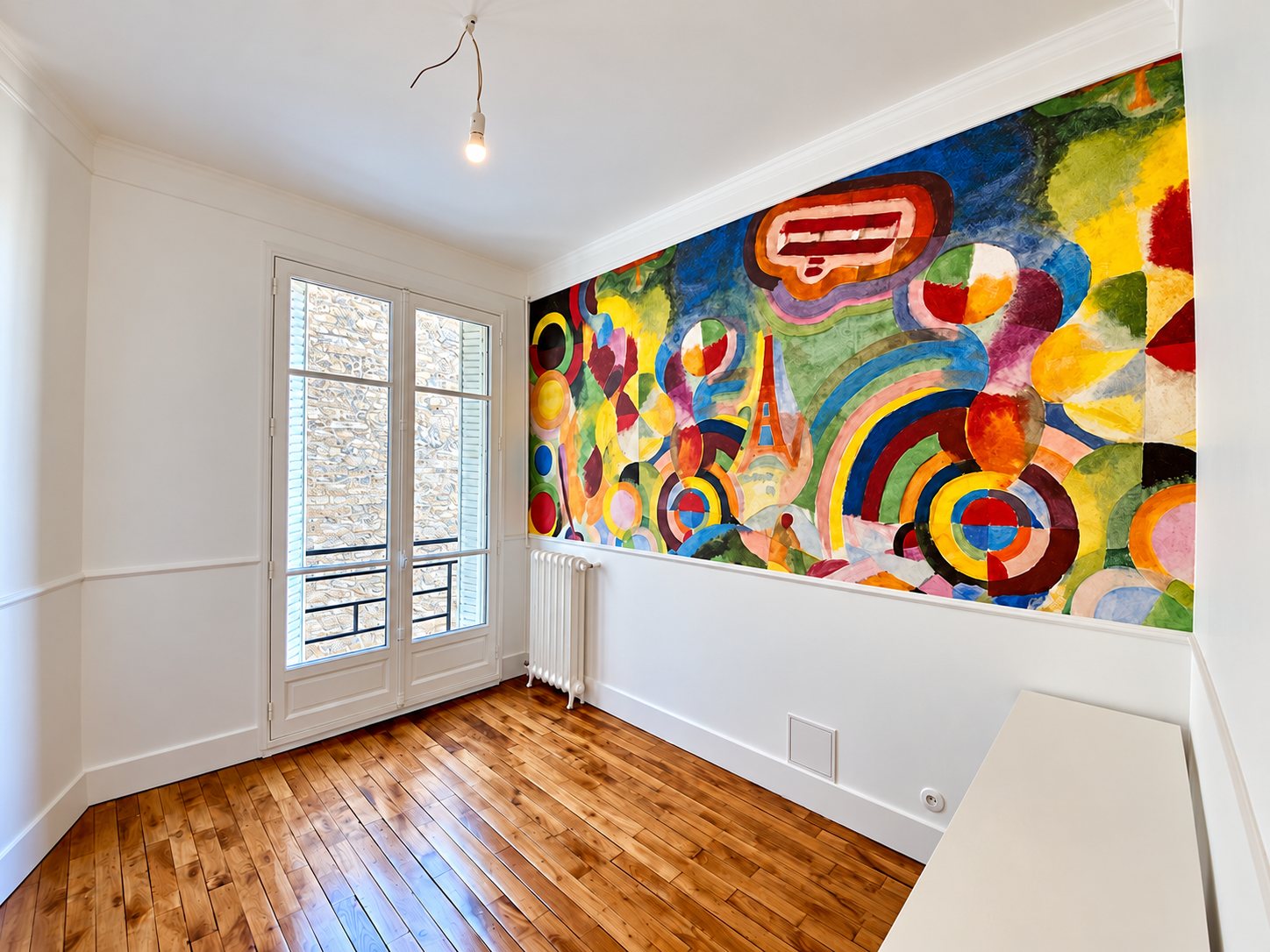 Pièce rénovée avec fresque murale colorée et parquet ancien